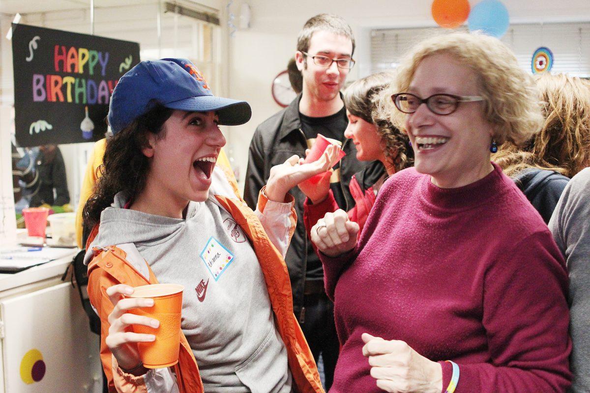 Adrianna Bogozian, junior in Math, and Professor Sacco celebrate during the birthday party for OUTREACH LGBT &amp; Ally Resource Center. They served cupcakes and cookies and had a birthday sign for guests to sign.