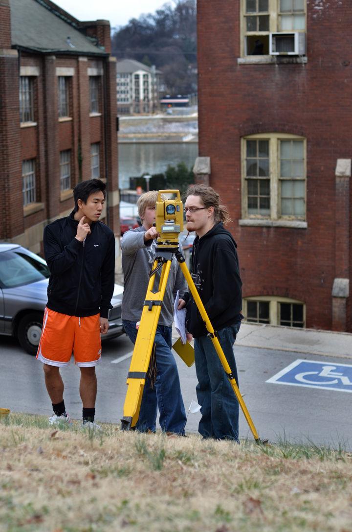 Kevin Khoo, Cody Mitchell, and Tyler Bone, all sophomores in civil engineering, perform land surveying for Geomatics 210 outside of Estabrook Hall on Tuesday, Feb. 15.