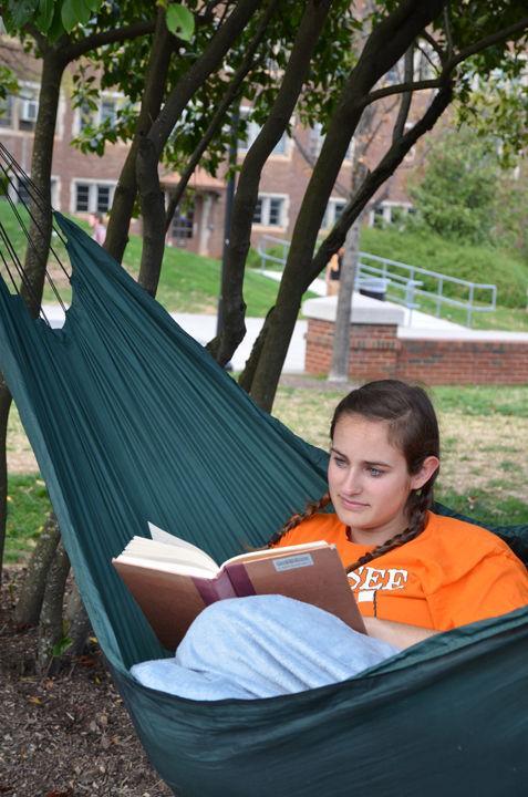 Kati Rook, junior in deaf education, rests in a hammock along the Pedestrian Mall on a sunny Tuesday, March 22.
