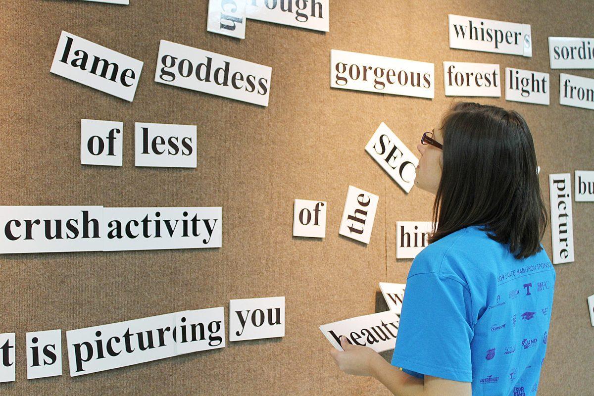 Natalie Williams, senior in therapeutic recreation, looks for words to use on the poetry stick board Feb. 7. The poetry stick exhibit was taken down Wednesday.