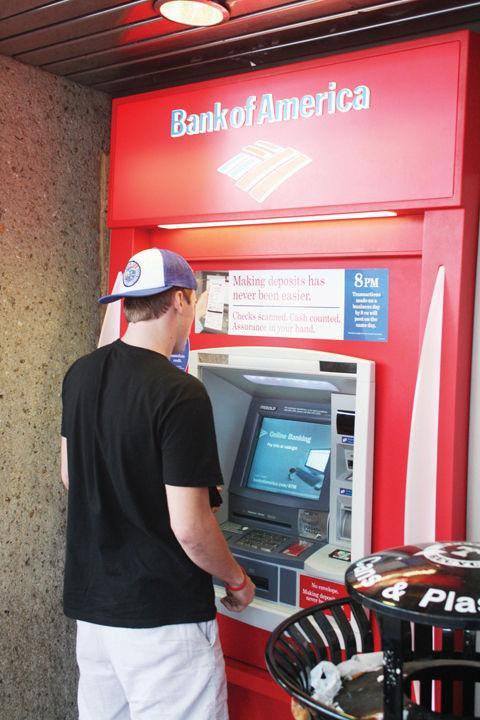 Steven Lewandowski, sophomore in public relations, withdraws money from an ATM at the money wall on Nov. 10, 2011. The money wall, which once housed ATMs from a number of local and national banks, now has no ATMs available in preparation for demolition of the UC parking garage. This is the first stage of many moving towards the completion of the new Student Union, to be completed in 2016.