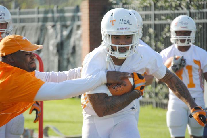 Running backs coach Jay Graham reaches to strip the ball from Rajion Neal during a drill at the first day of spring practice on Monday. Derek Dooley said that the running game was the offense's top priority heading into spring practice.