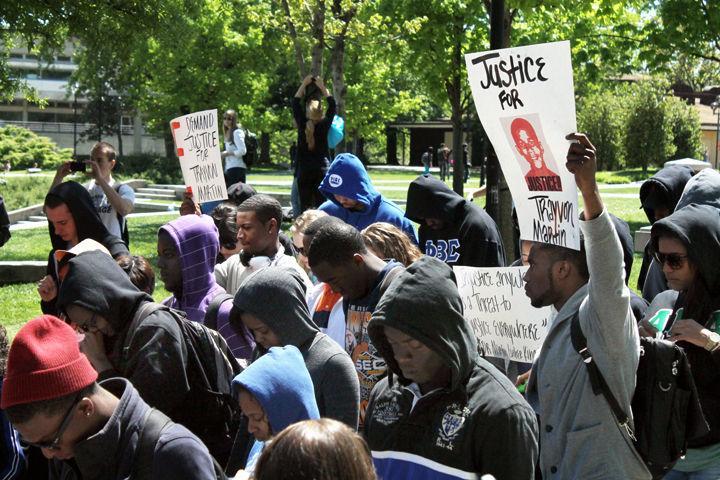 Students stand in silent prayer while others hold signs calling for justice during a march for Trayvon Martin on the Pedestrian Mall on Thursday.