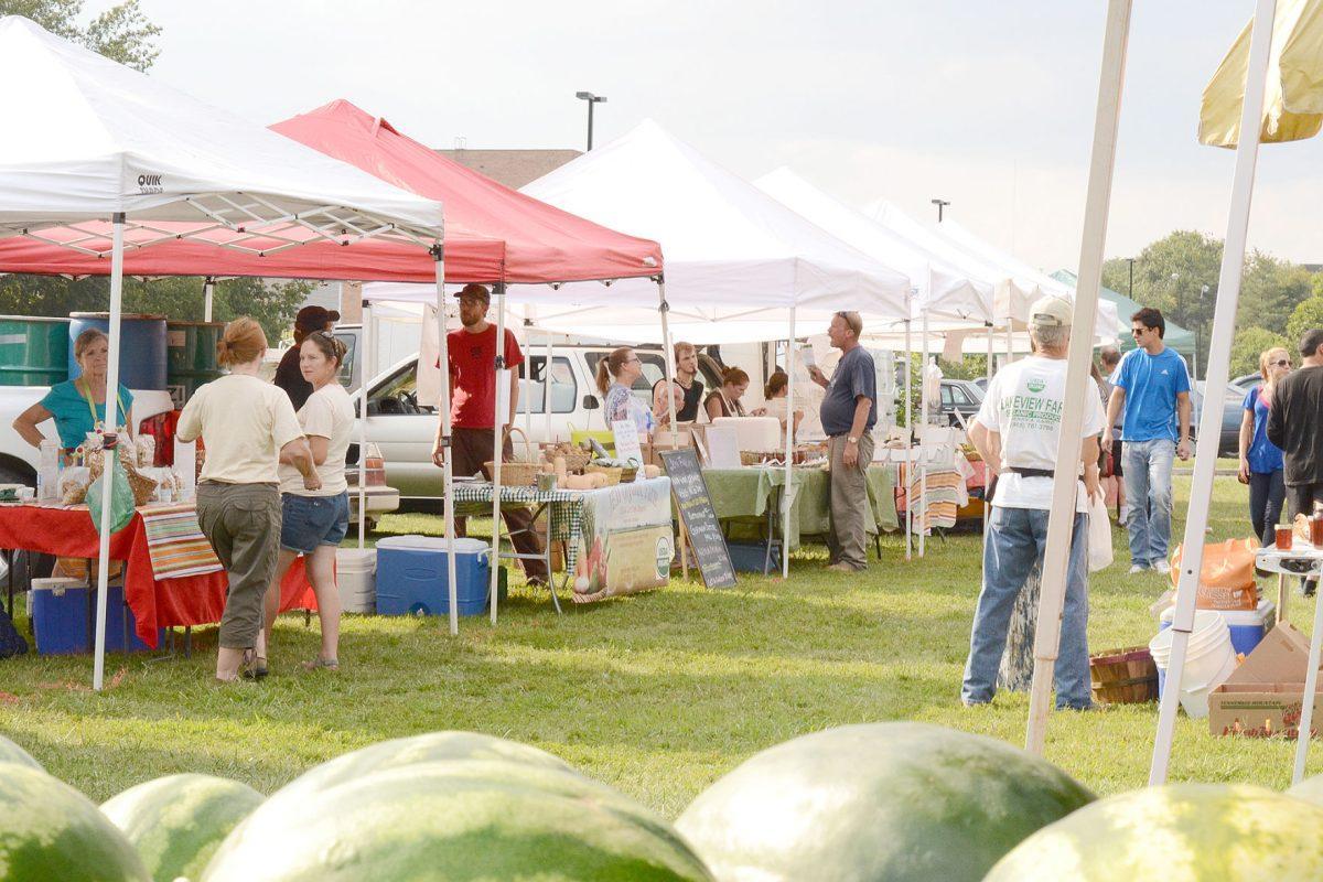 Members of the Knoxville community stop at local vendors for fresh produce at the UT Farmers Market on Wednesday at the UT Gardens.