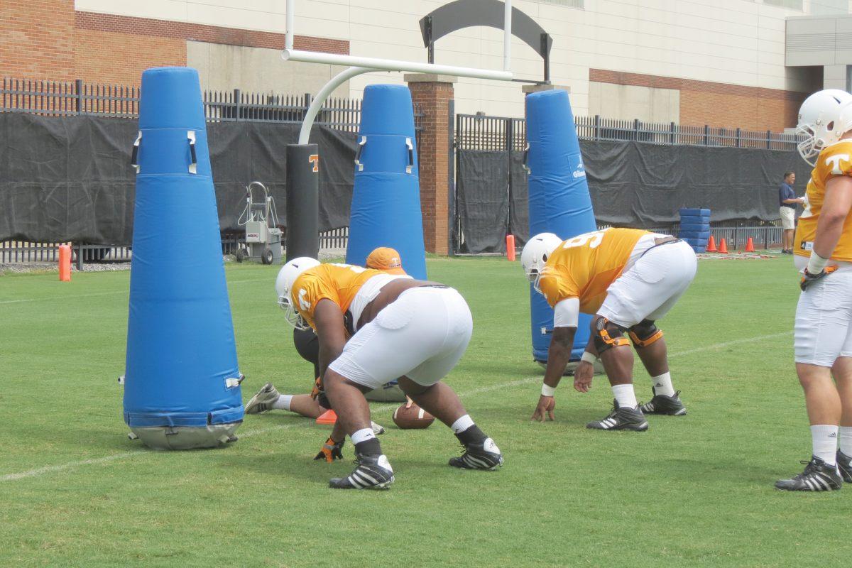 Linebackers line up to practice their tackles during a football practice during the summer.