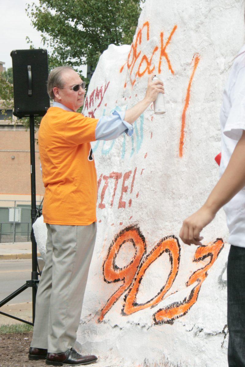 Jimmy Cheek spray paints the rock in a dedication ceremony on August 18, 2009. The Rock officially reopened for the start of the semester after construction crews completed the sidewalks.