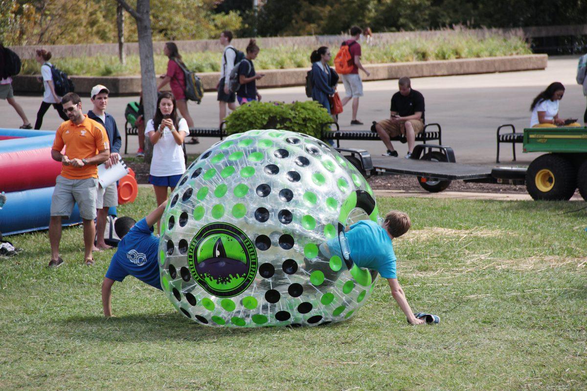 Abdelrahman Abdelwahed, freshman in buisness, and Dakota Brown, freshmen with pre-professional interests, make their way out of the zorb at the VolAware Street Fair on Oct. 3.