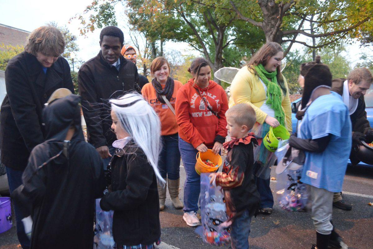 Children in costumes receive candy from students in Circle Park on Monday, Oct. 29.