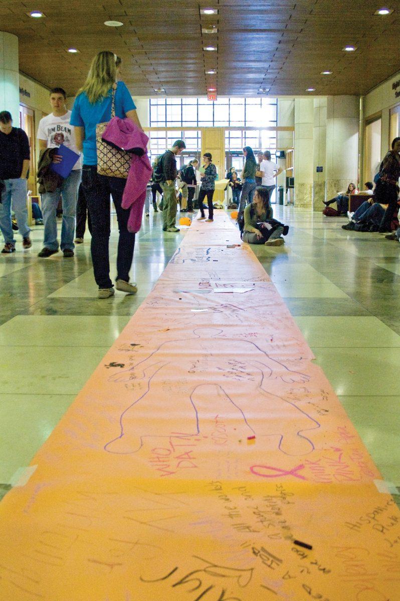Students examine and write on the graffiti walkway in Hodges Library in 2009.