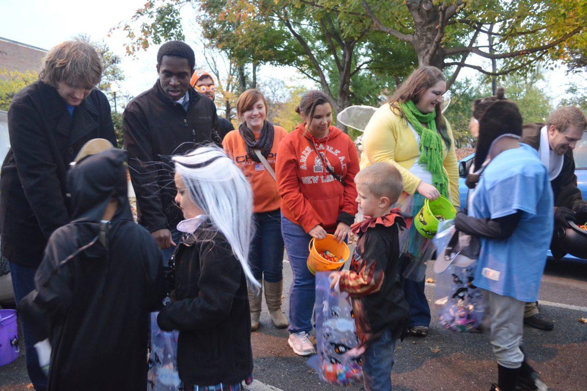 Children in costumes receive candy from students in Circle Park on Monday, Oct. 29.