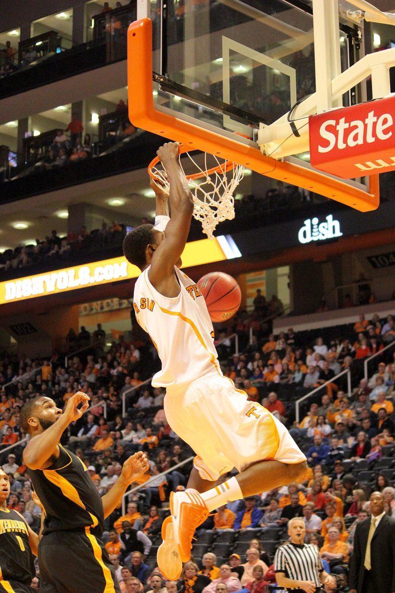 Sophomore guard Josh Richardson momentarily hangs on to the rim after a two-handed jam in the Kennesaw State game on Nov. 9. Richardson is averaging nearly eight points and six rebounds per a game on the season.