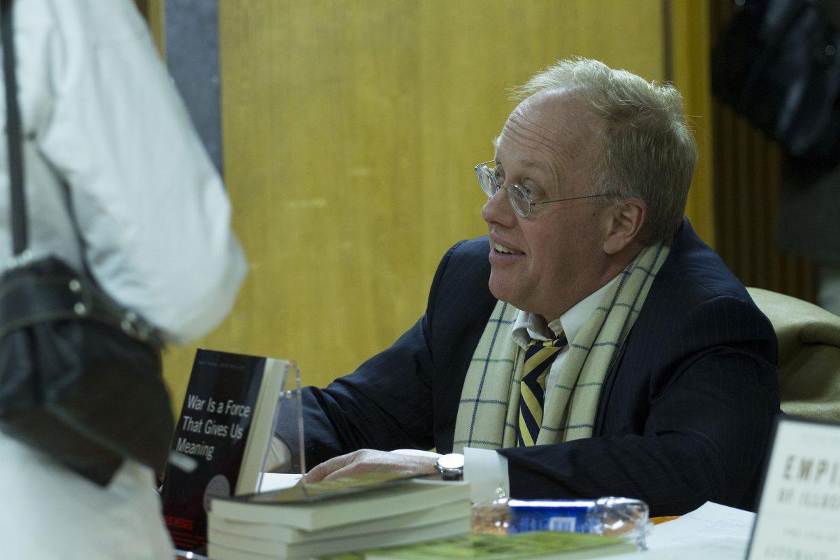 Chris Hedges autographs various books after a lecture on Tuesday.