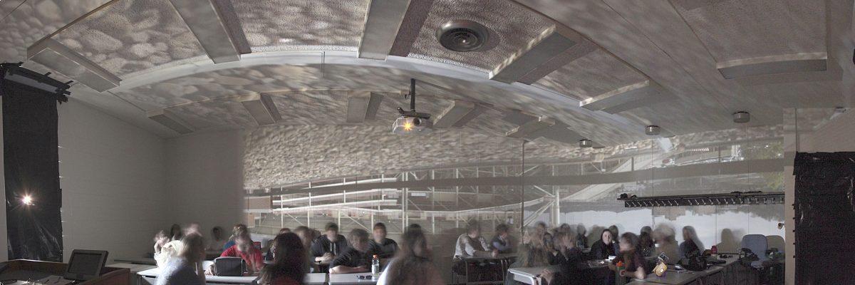 Photojournalism professor Robert Heller created a classroom pinhole camera by blocking all light in the room except for a nickel-sized hole in the window to show how a camera reflects light upside down.