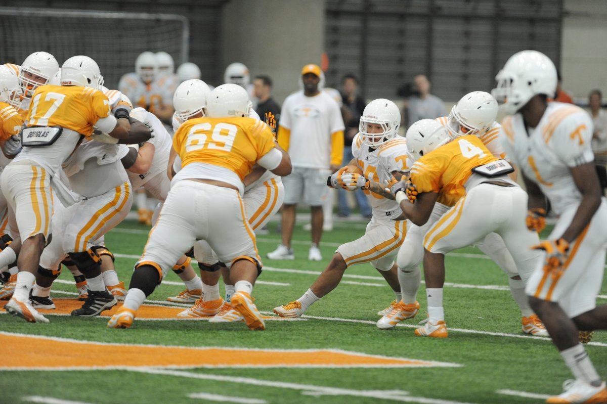 Alden Hill bursts through a hole in the line during spring practice on March 19.