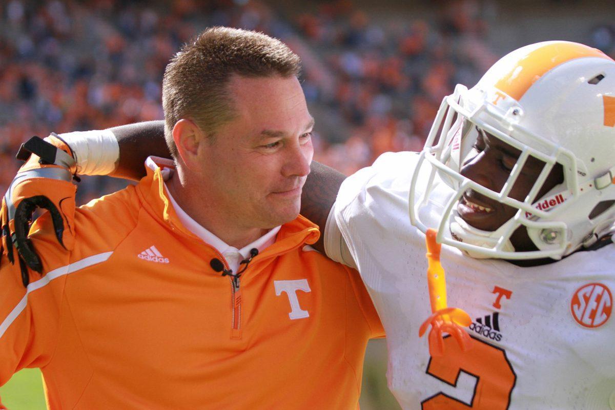 Head Coach Butch Jones celebrates with senior defensive back Byron Moore after the Orange and White game on Saturday.