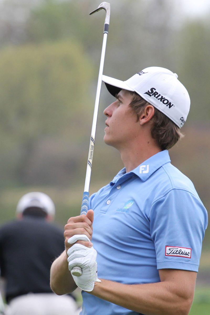 Freshman Oliver Goss eyes his shot on the driving range.