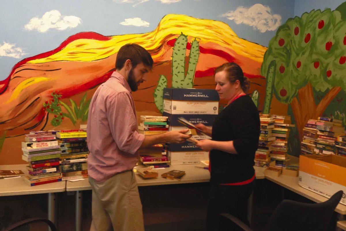 Chris Ludtka, junior in chemical engineering and Jessica Greene, an assistant public defender, sort donated books in the Community Law Office. This month's drive will benefit up to 1,500 inmates in the Knox County Detention Facility.