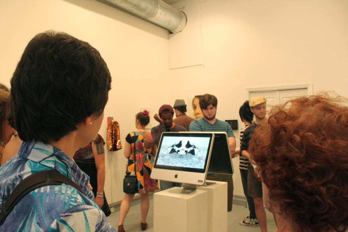 Guests in Gallery 1010 view a video that played the entirety of First Friday on August 2.