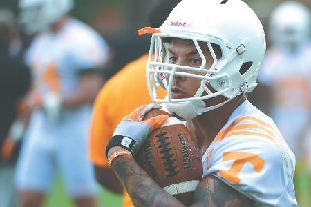 Alden Hill, running back, takes a hand-off during football training camp.