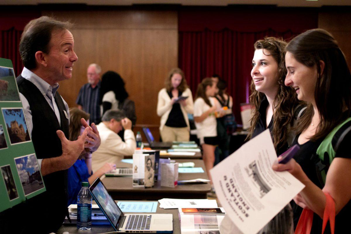 Gary Menendez talks with freshman students Katie Gaul, middle, and Elizabeth Riffle about studying abroad in England and Scotland on at the Study Abroad Fair in the UC on Wednesday. The fair sought to show students the many opportunities they have to go abroad while they are in school.