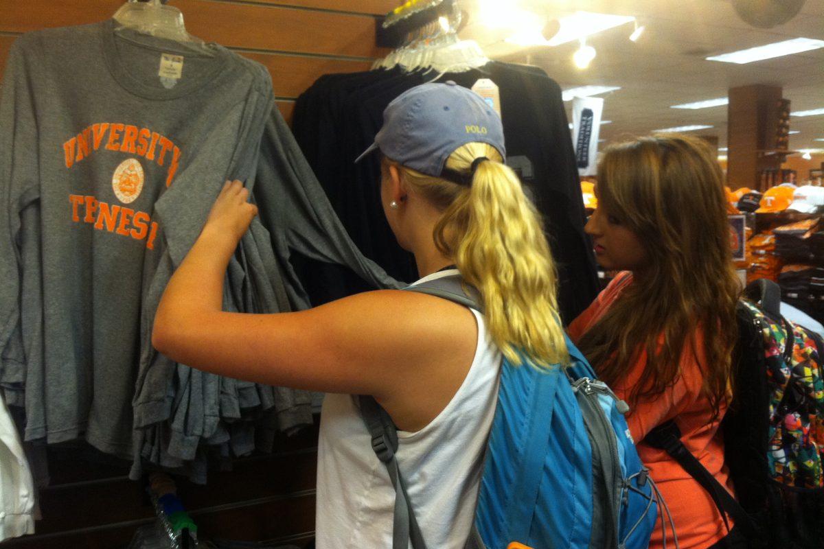 Rachel West, sophomore in biochemistry, and Christen Cox, sophomore in business, rifle through American Thread's long sleeved sporty tees at the UT bookstore.