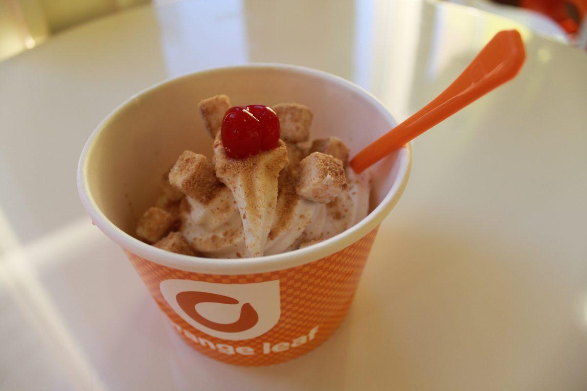 Orange Leaf Pumpkin Pie frozen yogurt topped with cheesecake bites and a cherry.