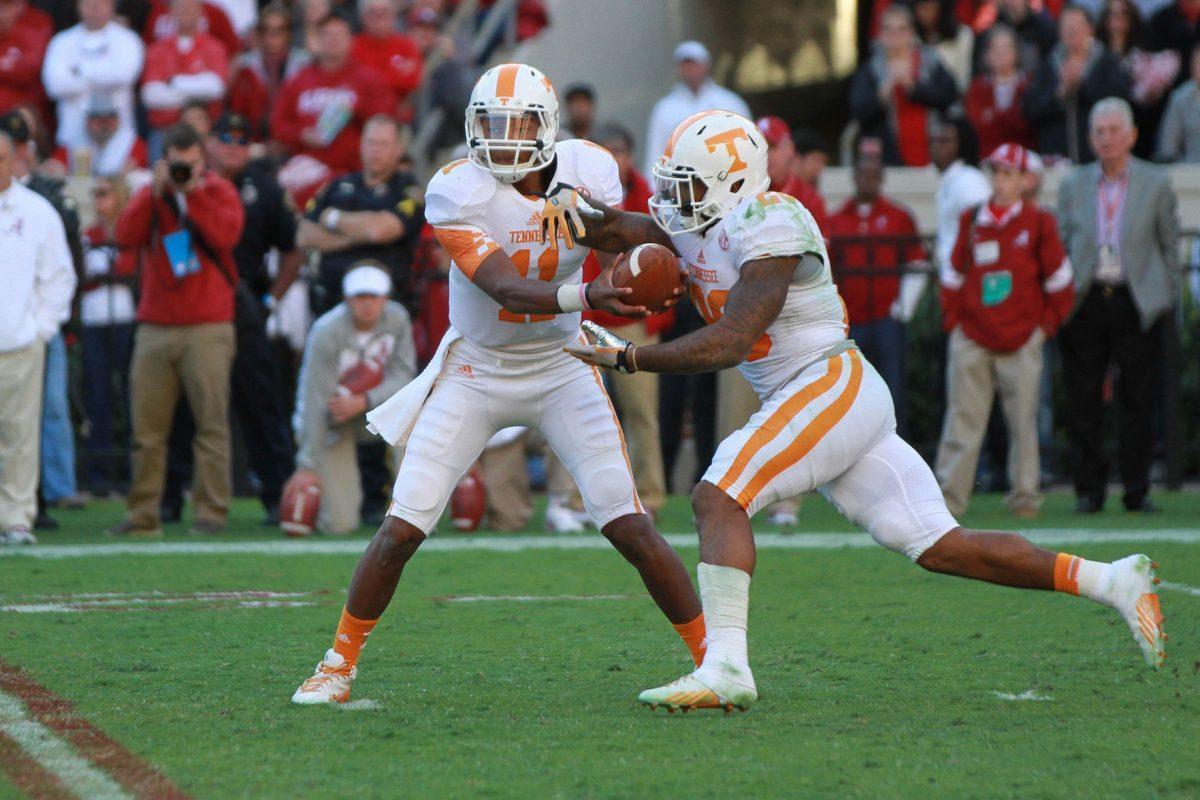 Tennessee reshman quarterback Joshua Dobbs hands off to Rajion Neal during UT's 45-10 loss against Alabama at Bryant-Denny Stadium on Saturday. Dobbs played for the first time this season – burning his redshirt status – after starting quarterback Justin Worley injured his hand near the end of the first half.