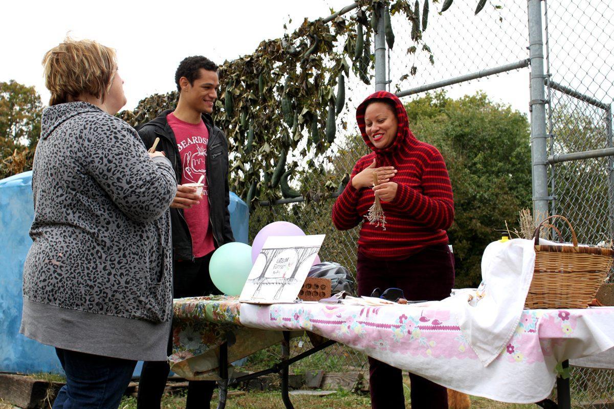 Cris Patterson, left, and Jordan Tallent, middle, listen to Rachel Wanyoike explain the benefits of seed saving and herb drying on Oct. 26 at the Beardsley Farm Fall Harvest Festival.