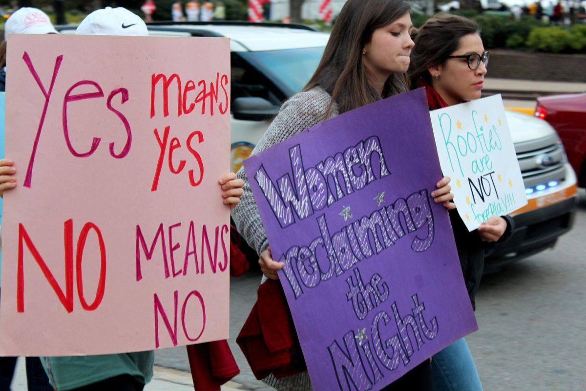 Students silently carry signs along Volunteer Boulevard during Take Back the Night, a march organized to raise awareness about sexual abuse, on Oct. 23.