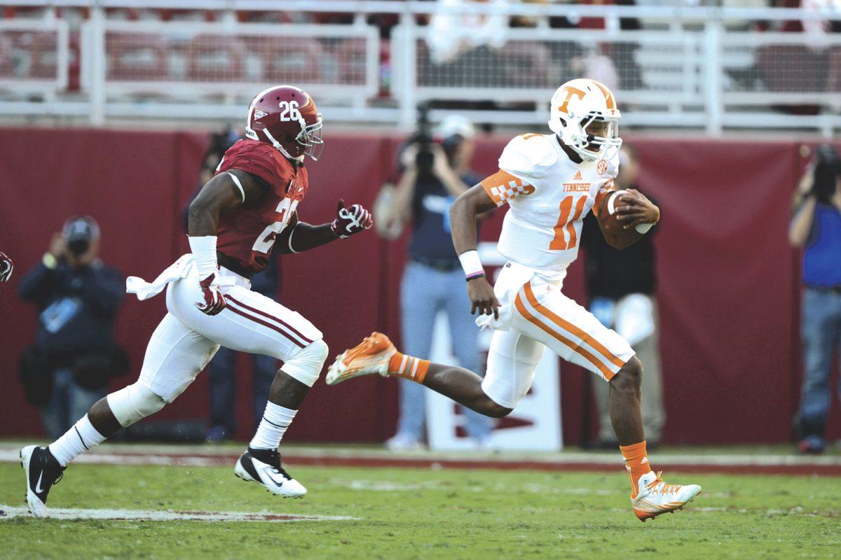 Tennessee true freshman quarterback Josh Dobbs narrowly outruns Alabama safety Landon Collins en route to an 11-yard carry during UT's 45-10 loss against Alabama at Bryant-Denny Stadium on Saturday.