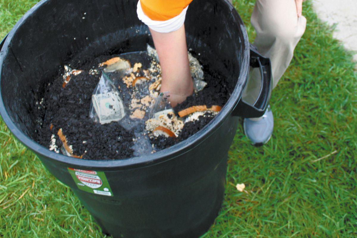 Michael Porter, senior in political science, takes the risk and reaches into a trashcan of sludge on Aug. 23 as a part of Campus Carnage's promotion.
