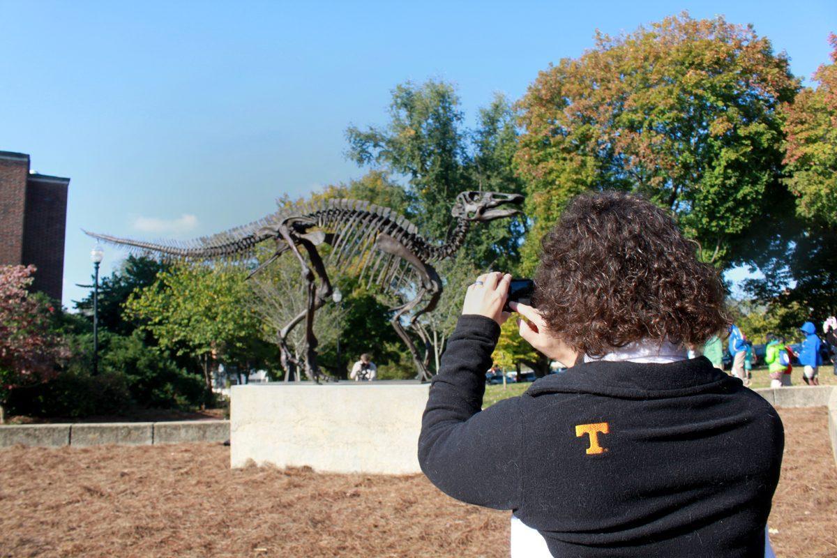 Angie Vicars, a web content manager for UT, snaps a photograph of the new dinosaur statue outside of McClung Musuem on Oct. 25.