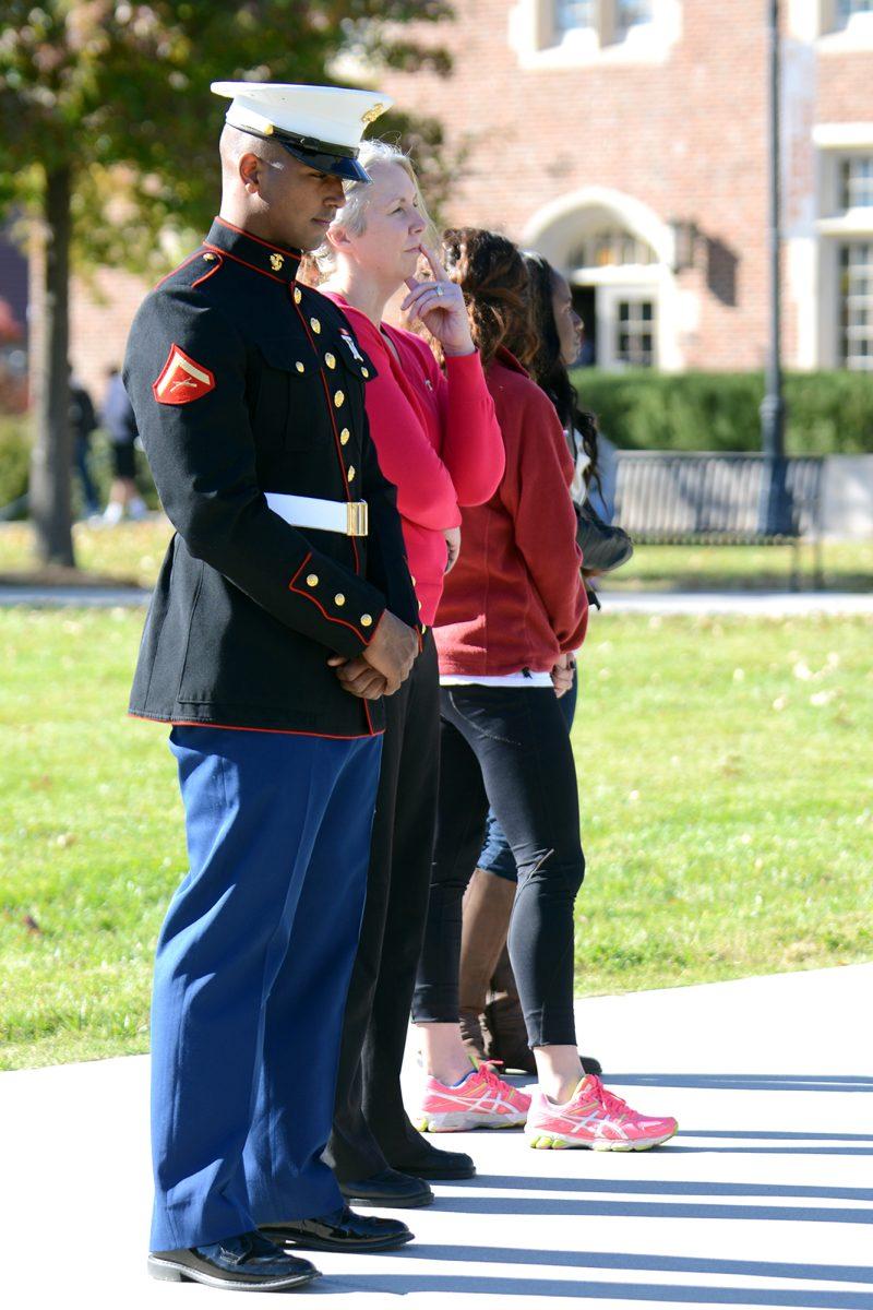 Lance Cpl. Jonathon Hairston, left, junior in disaster displacement in human rights, stands in a moment of remembrance as Dean of Students Maxine Davis does Roll Call. "The magnitude of what these men gave cannot be measured," Hairston said.