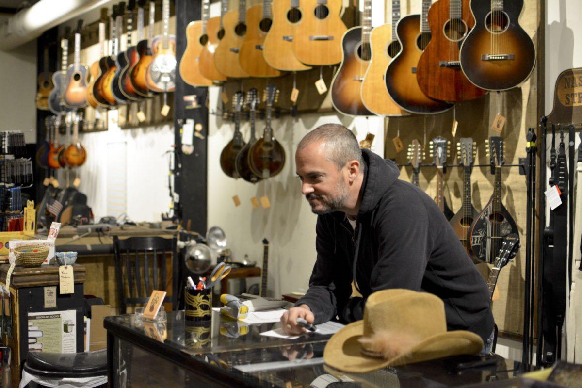 Josh Sidman, owner of The Parlor, waits patiently as a customer strolls through the shop.