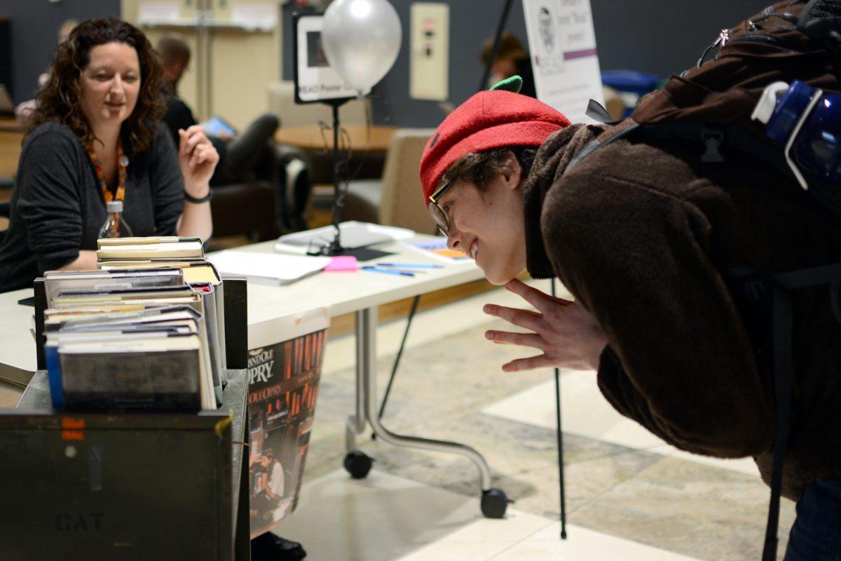 Bryn Lindsay, junior in accounting, eagerly chooses a book to pose with for the "Star in the Library" poster competition on Jan. 15 in Hodges Library.