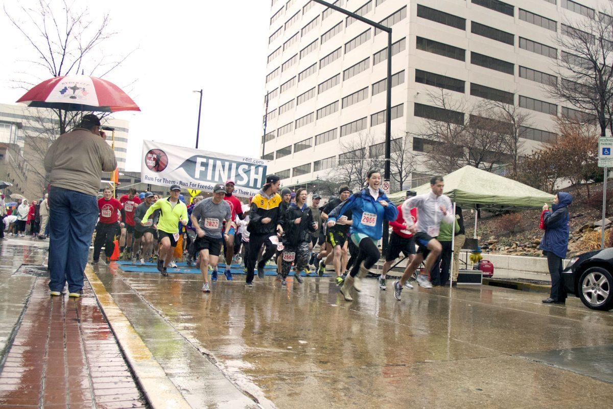 Participants sprint through the starting line in the first annual Knoxville "Run for Their Lives" race on Saturday at Market Square.The race, which had more than 800 participants, was organized to raise awareness of sexual exploitation and human trafficking of women and children around the world and provide financial support to those affected.