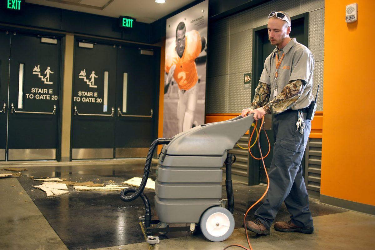 Johnathan Sawyers, a Facilities Services worker in the athletic department, cleans the floors inside Neyland Stadium on Thursday after several pipes burst and left puddles of standing water.