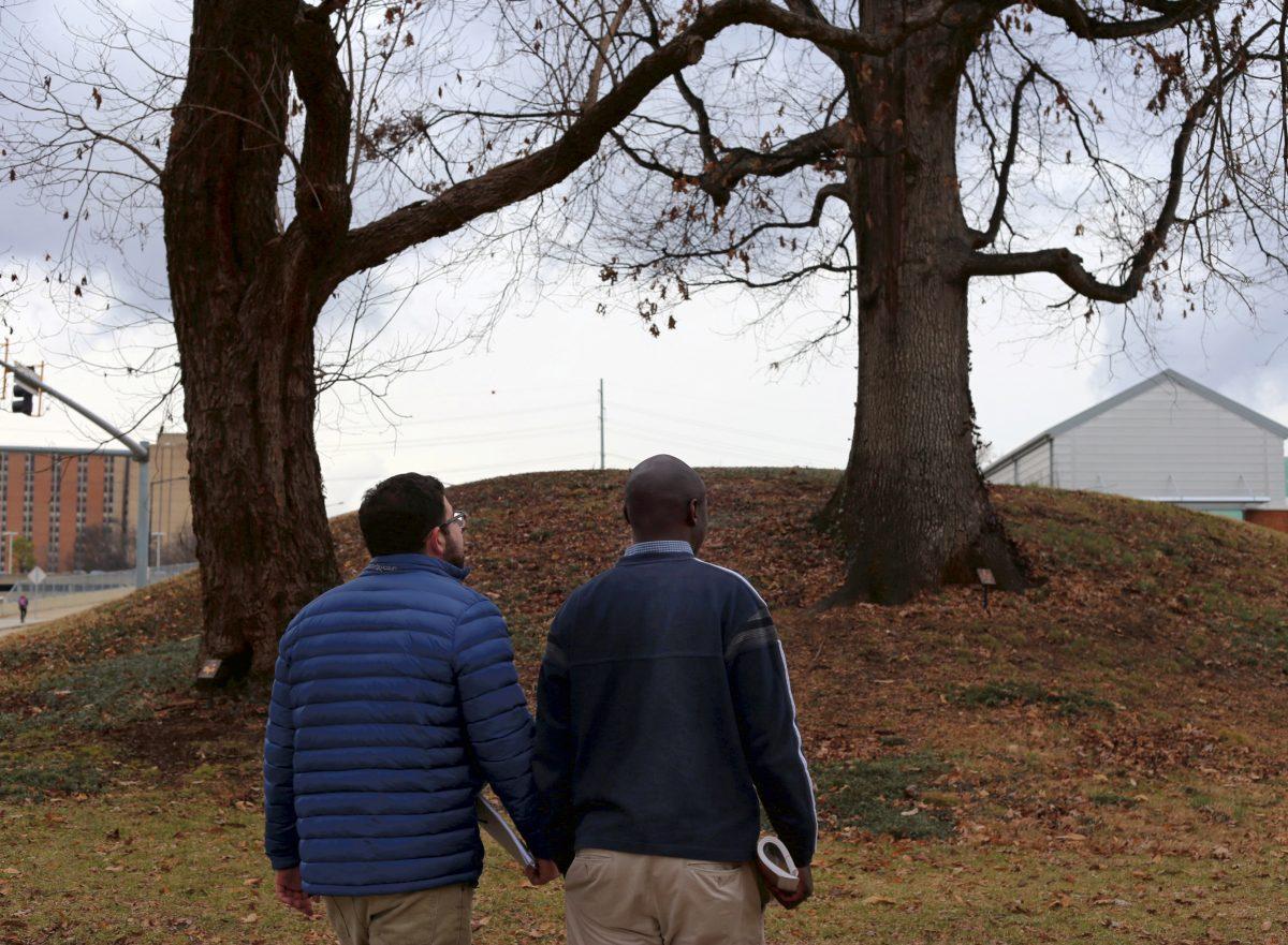 Adam Alsamadisi, left, and Njoroge Gathongo, two graduate students in geography, survey one of the last Native American burial mounds in East Tennessee on Wednesday. The site, located on the corner of Joe Johnson Drive and Chapman Drive, is estimated to be at least several hundred years old.