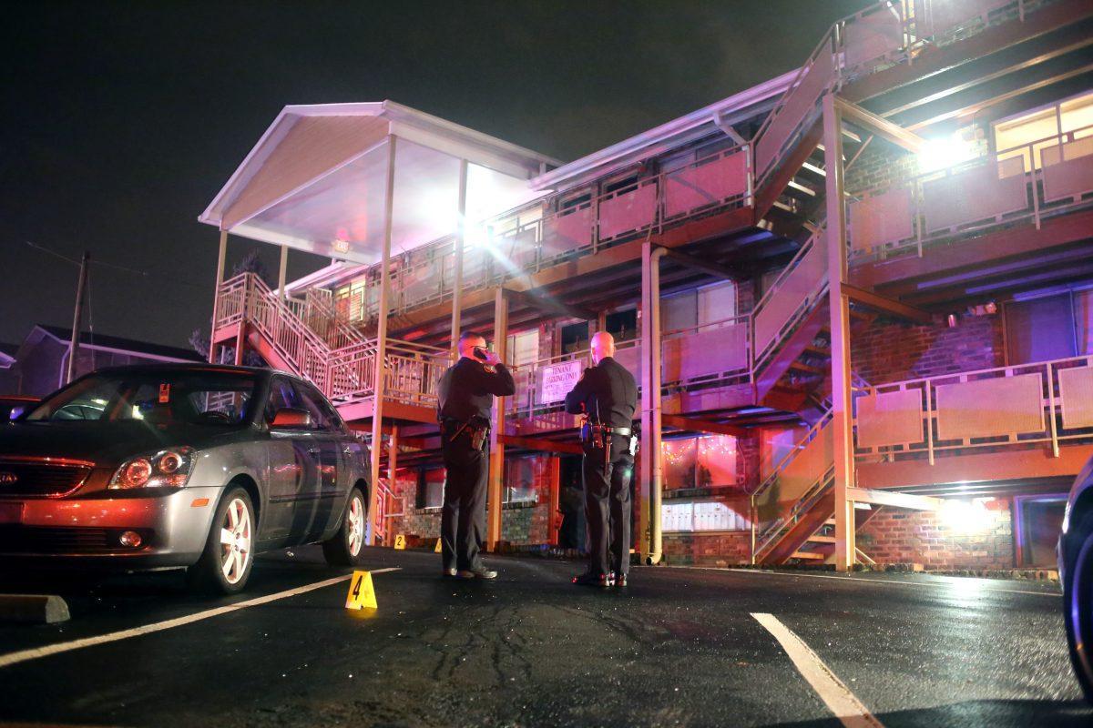 Two KPD officers examine the crime scene after a shooting at the Highland Terrace Apartment complex on the corner of 13th Street and Highland Avenue.