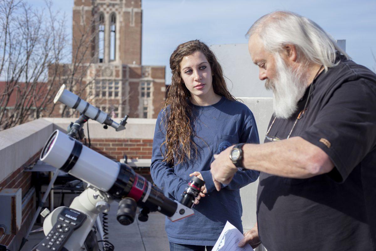 Paul Lewis, director of Space Science Outreach, right, and Maddie Bynum, freshman in child and family studies, discuss the elements of observing the sun using the telescopes atop Nielsen Physics on Feb. 17.