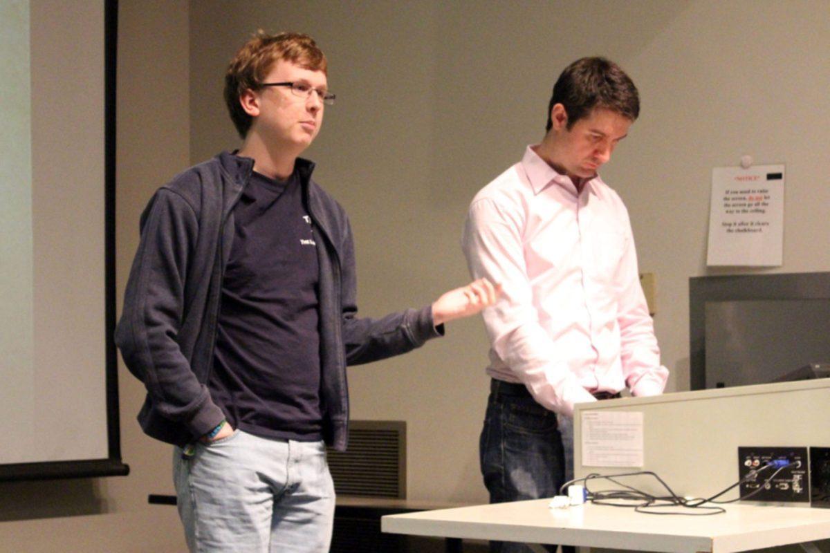 Nathan Smith, left, a freshman minoring in cinema studies and Richard Hermes, right, graduate student in English, provide a synopsis of the film before presentation. UT's English department hosted the first Surrealist Symposium Hodges Library auditorium on Sunday.
