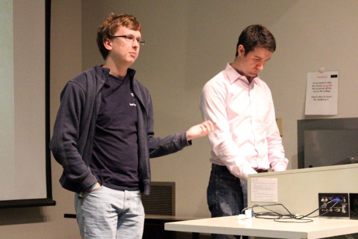 Nathan Smith, left, a freshman minoring in cinema studies and Richard Hermes, right, graduate student in English, provide a synopsis of the film before presentation. UT's English department hosted the first Surrealist Symposium Hodges Library auditorium on Sunday.