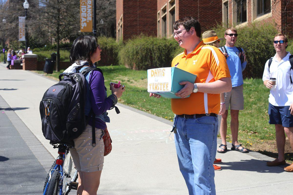 Grant Davis, running for the Board of Trustees position, speaks with a student on Pedestiran Walkway on Tuesday.
