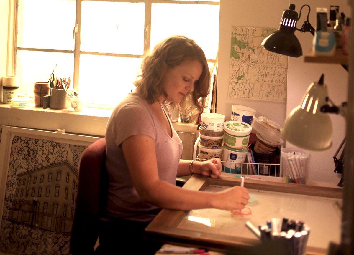 Beth Meadows, artist and director of 17th Street Studios, works on a window art project in her studio.
