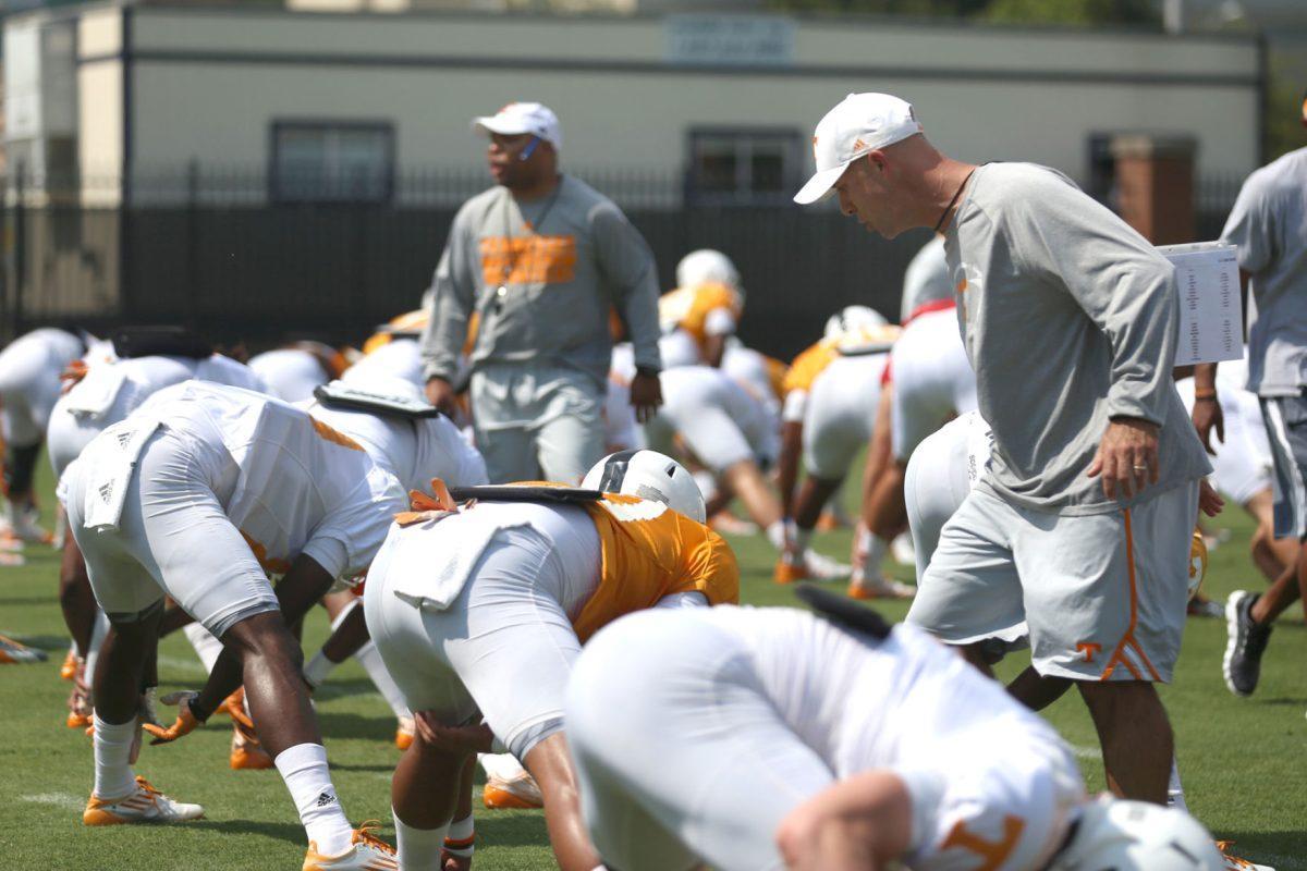 Defensive backs coach Willie Martinez instructs players during opening streches on Aug. 3 at fall football camp.