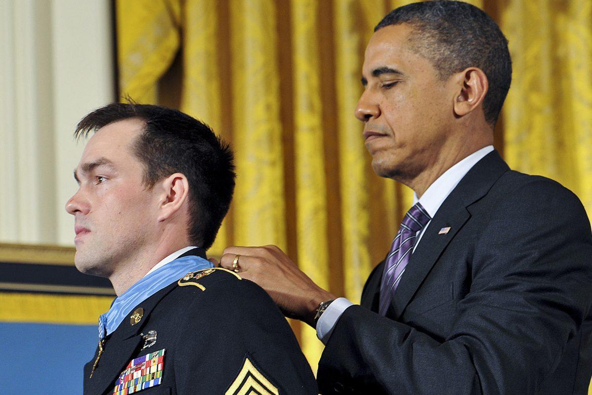 President Barack Obama places the Medal of Honor around the neck of Staff Sergeant Clinton Romesha during a ceremony on Feb. 11, 2013 at the White House.