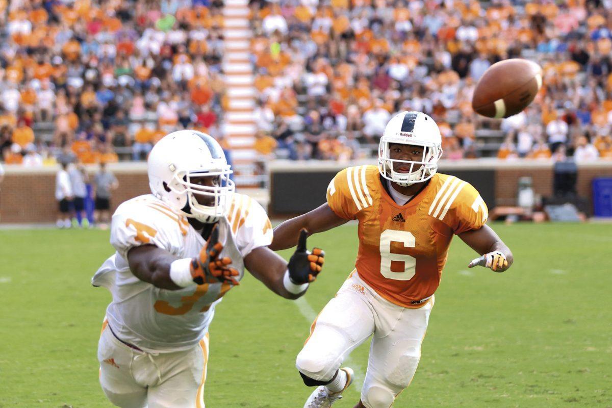 Freshman linebacker Neiko Creamer prepares to catch a pass while evading freshman defensive back Todd Kelly, Jr. during open practice in Neyland Stadium on August 16.