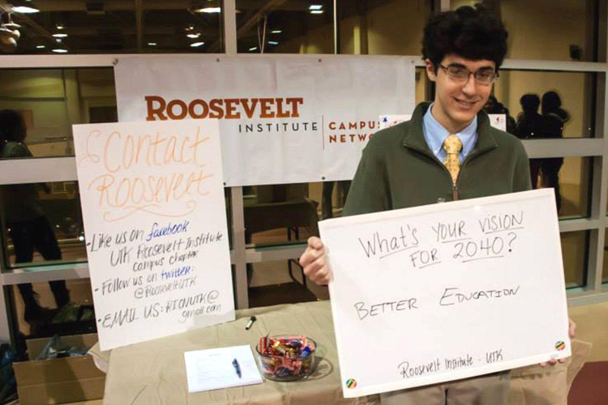 Louis Varriano, a member of the Roosevelt Institute on UT's campus, holds a sign that shares his hopes for the future.