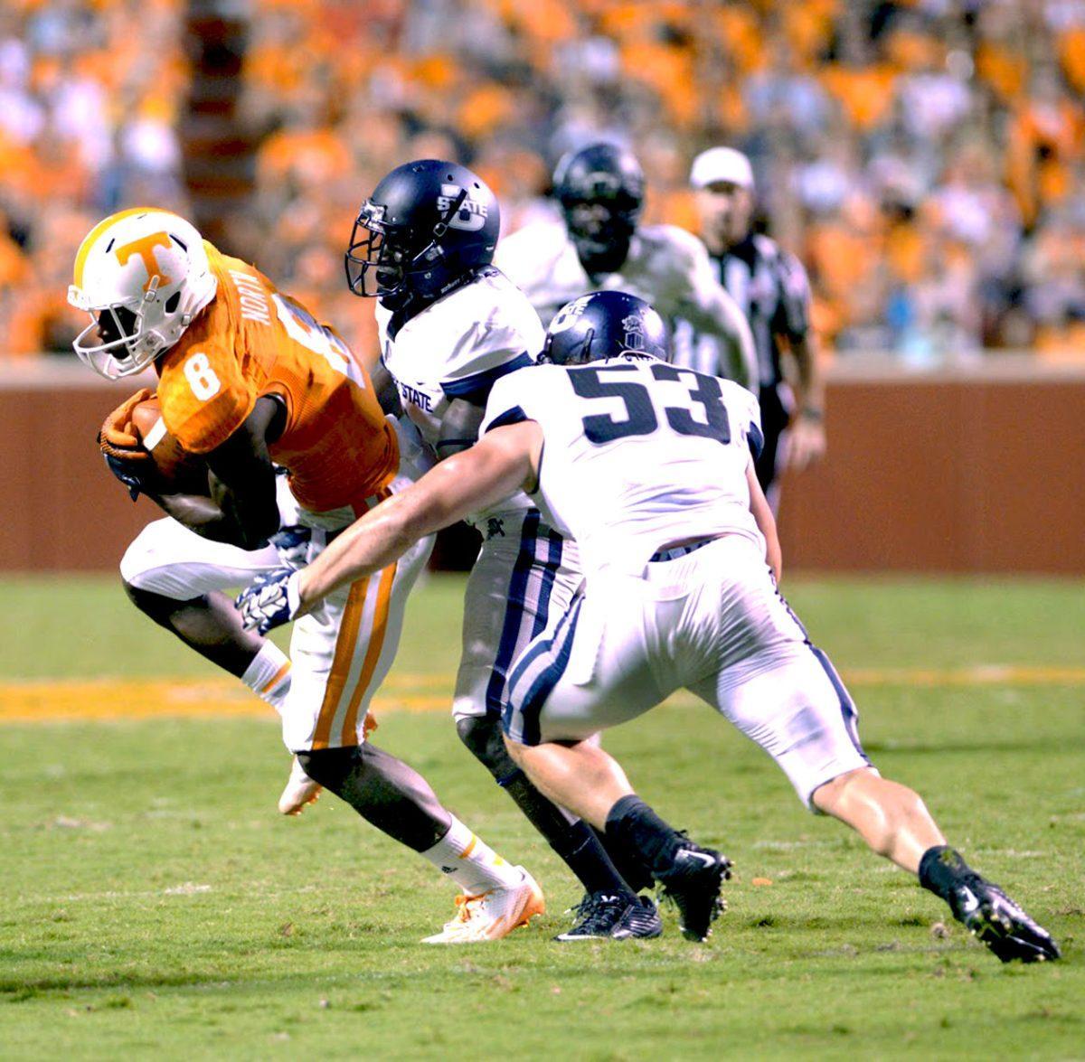 Marquez North attempts to pass the Utah State football players.