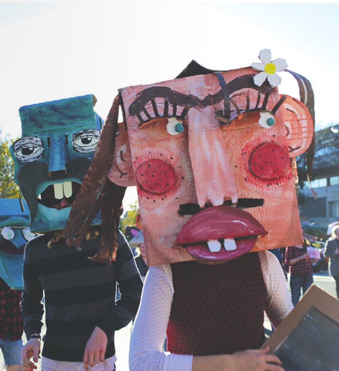 Students wear "hill-billy" masks during the 2013 Homecoming Parade.